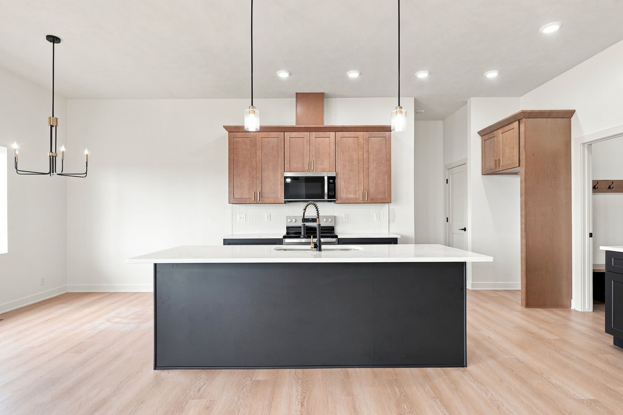 Empty kitchen and dining area with an island and no furniture.