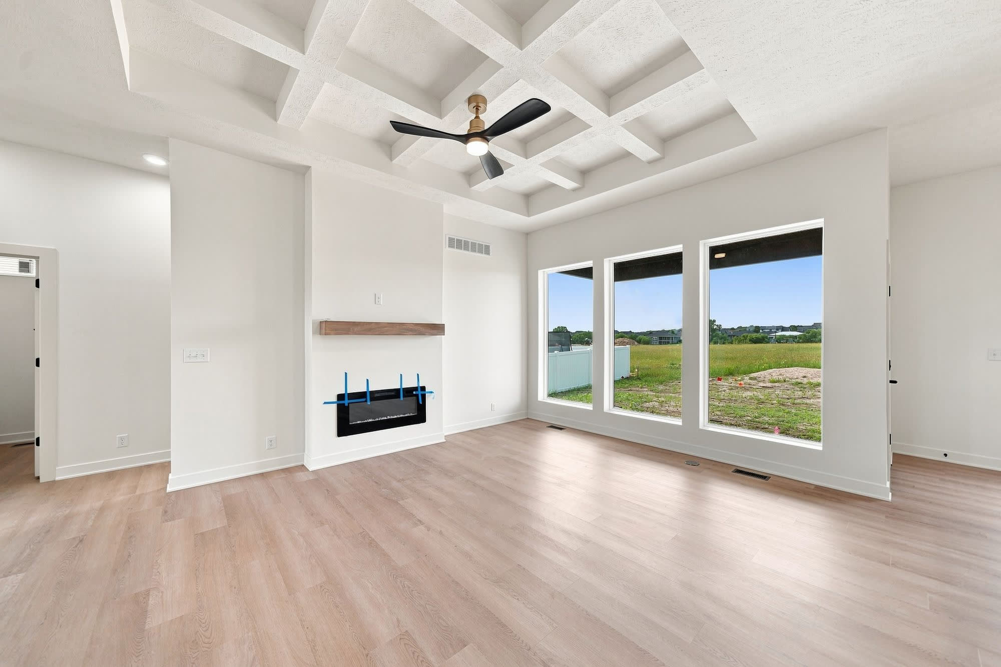 Empty living room with three windows.